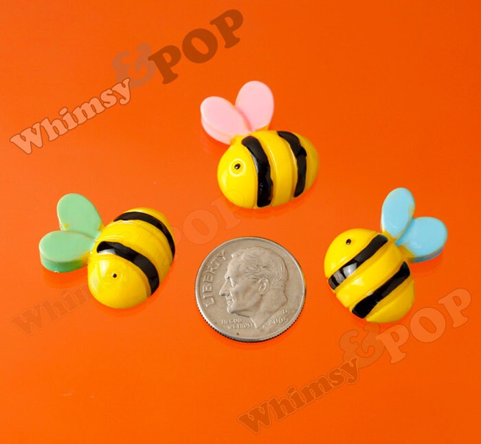Bee Embellishments and bumble bee cabochons next to a coin